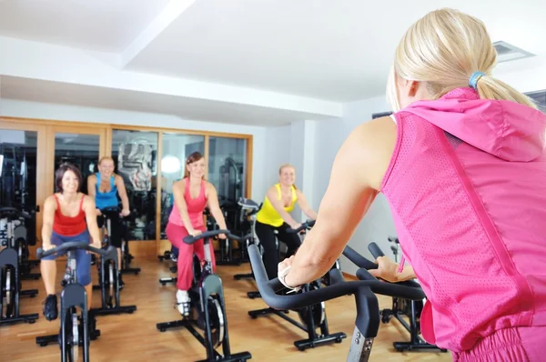 Vackra kvinnor gör övning i en spinning klass på gym — Stockfoto