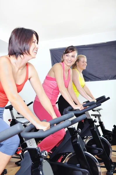 Hermosas mujeres haciendo ejercicio en una clase de spinning en el gimnasio — Foto de Stock