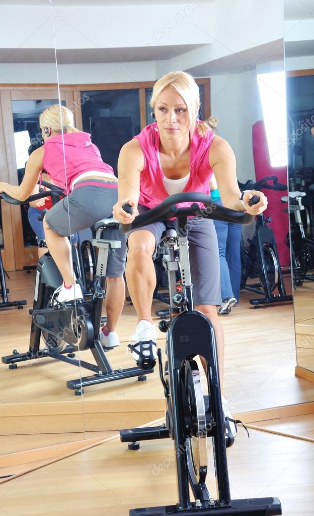 Beautiful woman doing exercise in a spinning class at gym