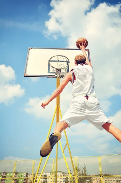 Jugador de baloncesto en acción volando alto y anotando — Foto de Stock