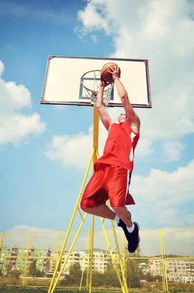 Jugador de baloncesto en acción volando alto y anotando —  Fotos de Stock