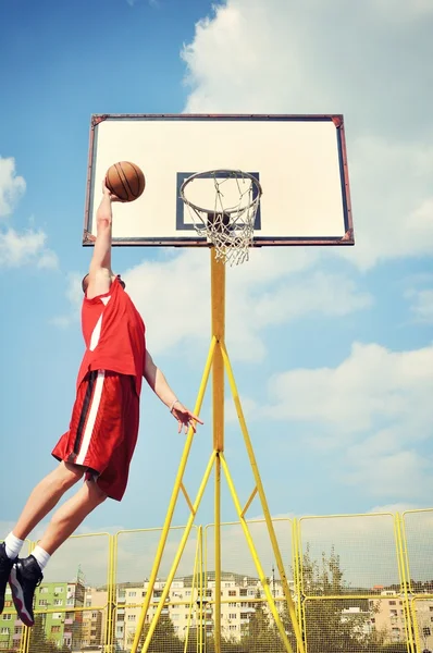 Giocatore di basket in azione volando alto e segnando — Foto Stock