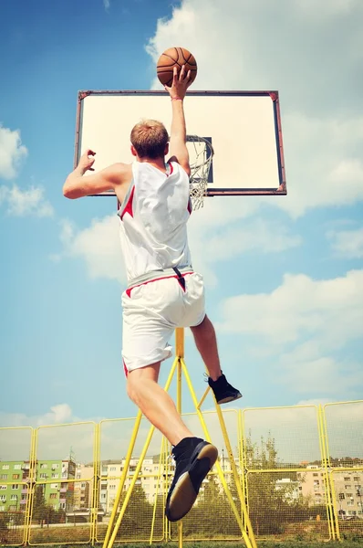 Jugador de baloncesto en acción volando alto y anotando —  Fotos de Stock