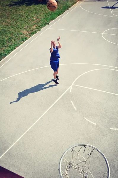 Jogador de basquete pulando e atirando a bola — Fotografia de Stock