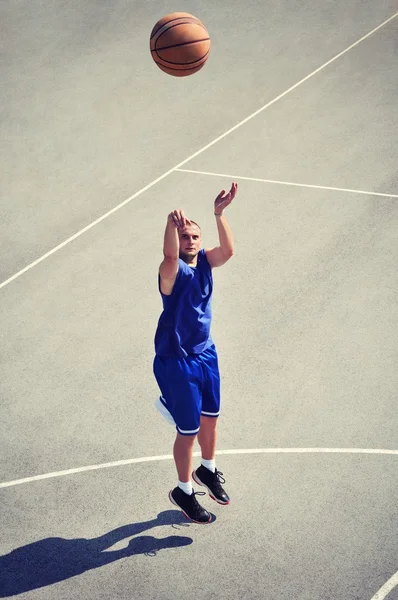 Jugador de baloncesto saltando y disparando la pelota — Foto de Stock