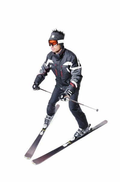 Um esquiador masculino esquiando com equipamento completo em um fundo branco — Fotografia de Stock