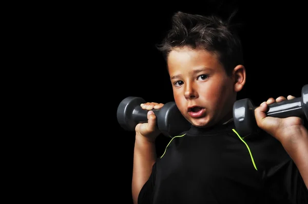 Retrato de criança bonita fazendo exercício com halteres — Fotografia de Stock