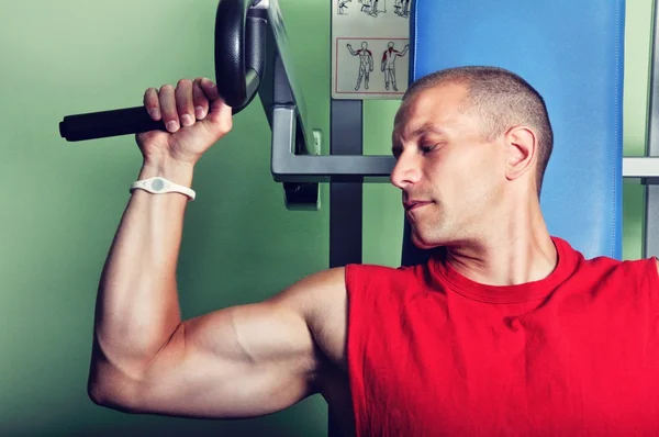 Uomo muscolare che esercita in una palestra — Foto Stock