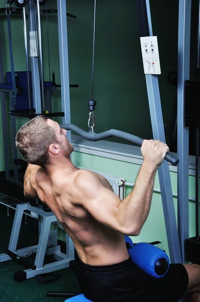 Muskulöser Mann beim Training in einem Fitnessstudio — Stockfoto