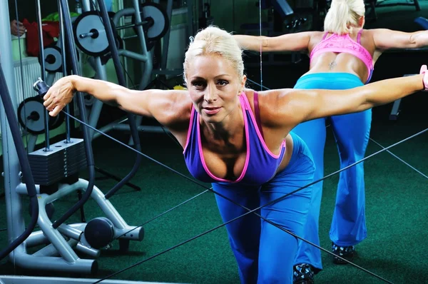 Bella donna muscolosa che si esercita in palestra — Foto Stock