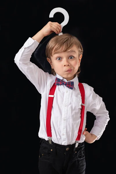 Adorable petit garçon d'âge préscolaire joliment habillé tenant signe de question. Photos De Stock Libres De Droits