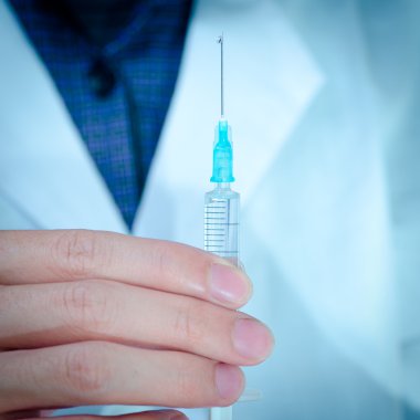 Elinde şırınga olan bir doktor.