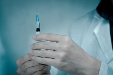 Elinde şırınga olan bir doktor.