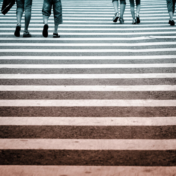 Pedestrians in modern city zebra crossing road