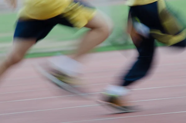 Niño corriendo en pista deportiva movimiento borroso — Foto de Stock