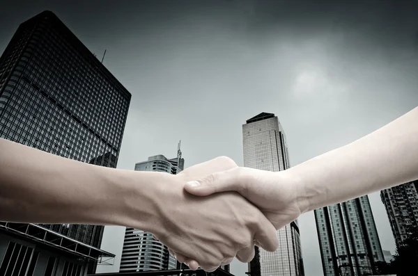 Stretta di mano di affari su città moderna — Foto Stock