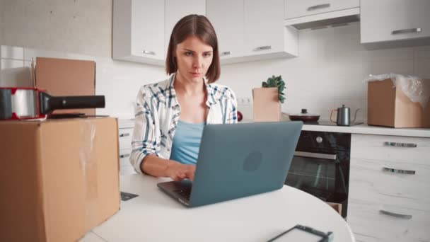 Mecanografía femenina en la computadora en la cocina — Vídeos de Stock