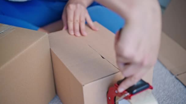 Pessoa usando fita adesiva embalar item — Vídeo de Stock