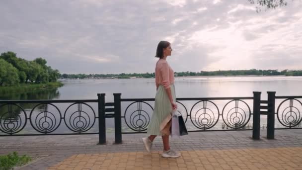 女性は川の前を歩き — ストック動画
