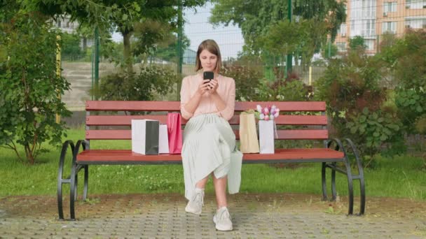 Genç bir kadın elinde akıllı telefon mesajları tutuyor. — Stok video