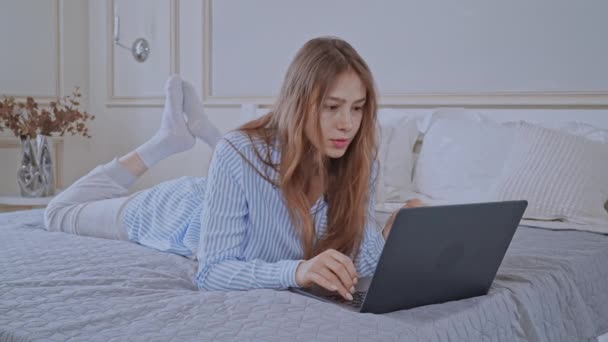 寝室でコンピュータを使っている白人女性は — ストック動画
