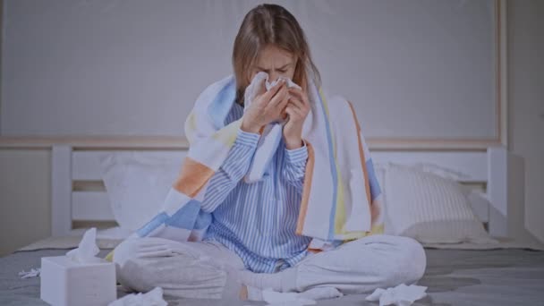 Wanita sakit dengan dingin di kepala duduk di kamar tidur — Stok Video