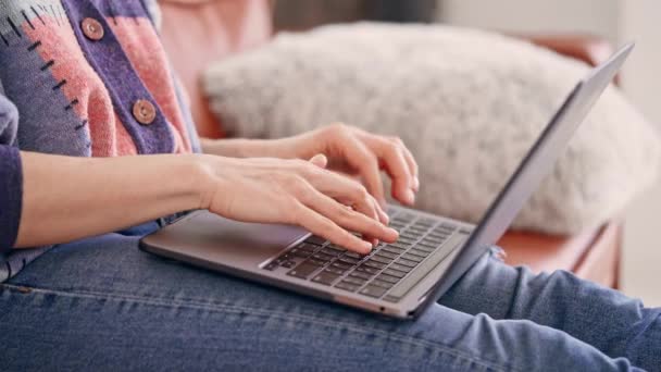 Неузнаваемая женщина, пользующаяся компьютером дома — стоковое видео