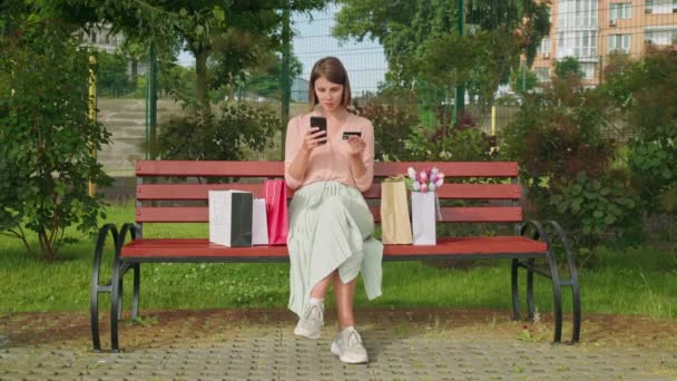 Kobieta posiadająca smartfon i kartę kredytową — Wideo stockowe