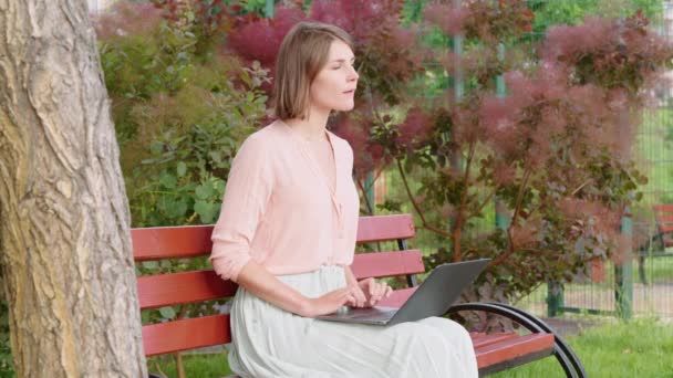 Vrouw freelancer werken in park — Stockvideo