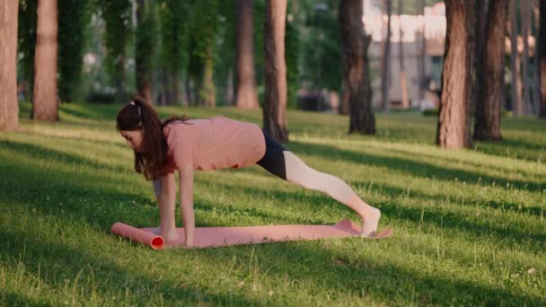 Atleet doet flexibiliteitsoefeningen in het park — Stockvideo