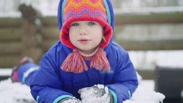 Carino Bambina Vestita Colorato Cappello Maglia Sdraiato Sulla Neve Adorabile — Video Stock