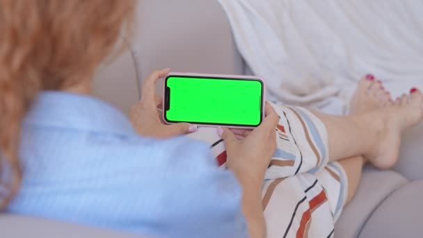Shoulder View Woman Holding Smartphone Green Screen Indoors Sitting Sofa — Vídeo de Stock