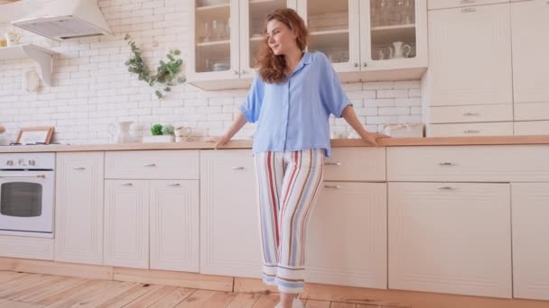 Радісна Леді Позує Квартирі Вранці Одягнені Елегантні Піжами Стоять Кухні — стокове відео