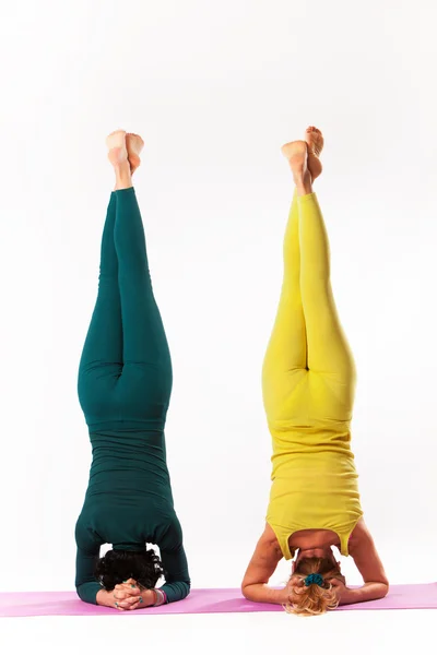 Äldre och yngre kvinna träna yoga — Stockfoto