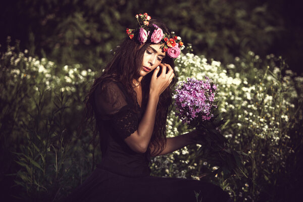 Young beautiful woman portrait with flowers in field summer day retro colors