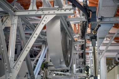 Perçinlenmiş çelik kirişleri, çelik kablosu ve gondolu olan bir teleferiğin çelik yapımı.