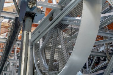 Perçinlenmiş çelik kirişleri, çelik kablosu ve gondolu olan bir teleferiğin çelik yapımı.