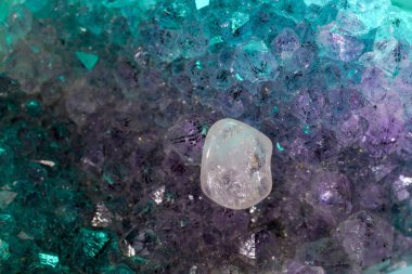 Kuvars, arka planda Marco modunda çekilmiş mineral içerikli bir arka plan önündedir.                     