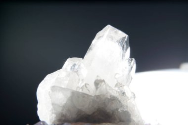 Kuvars, arka planda Marco modunda çekilmiş mineral içerikli bir arka plan önündedir.                     
