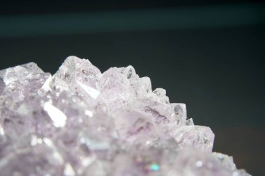 Kuvars, arka planda Marco modunda çekilmiş mineral içerikli bir arka plan önündedir.                     