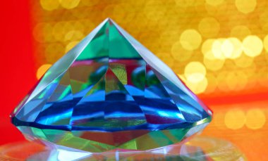 Stüdyoda çekilen parlak kesimli yeşil elmaslar renkli bir arka plana sahip.