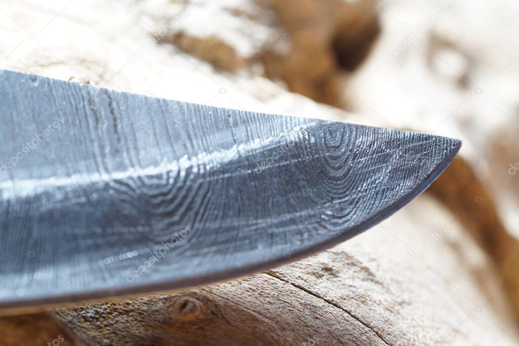 Damask Hand-forged knife made of several layers of steel with an exclusive pattern photographed in the studio