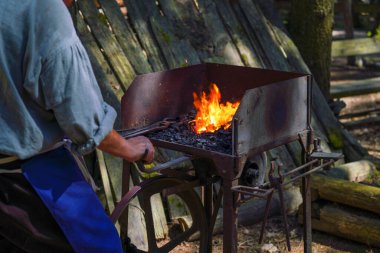 Demirci kızgın demirle çalışıyor.                             