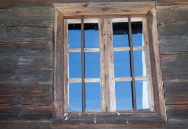 Wooden window with glazing and partially weathered in rustic homes