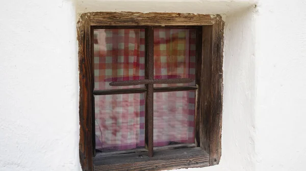 Wooden window with glazing and partially weathered in rustic homes