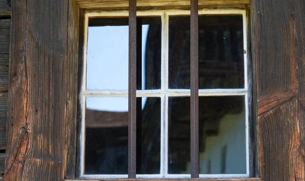 Wooden window with glazing and partially weathered in rustic homes