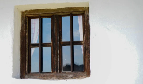 Wooden window with glazing and partially weathered in rustic homes