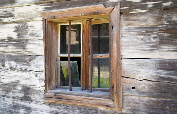Wooden window with glazing and partially weathered in rustic homes
