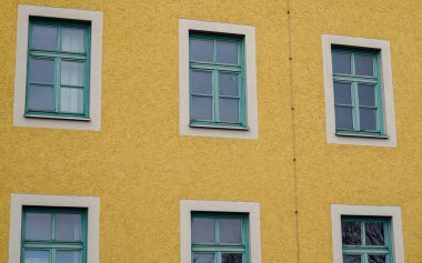 Penceresi pencereli bir binanın ön cephesi