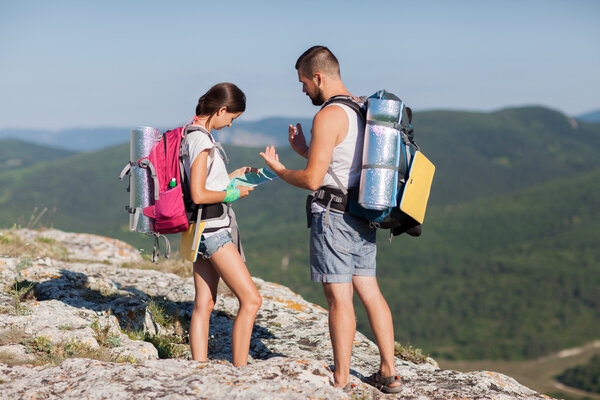 Туристы с рюкзаками наслаждаются видом на долину
